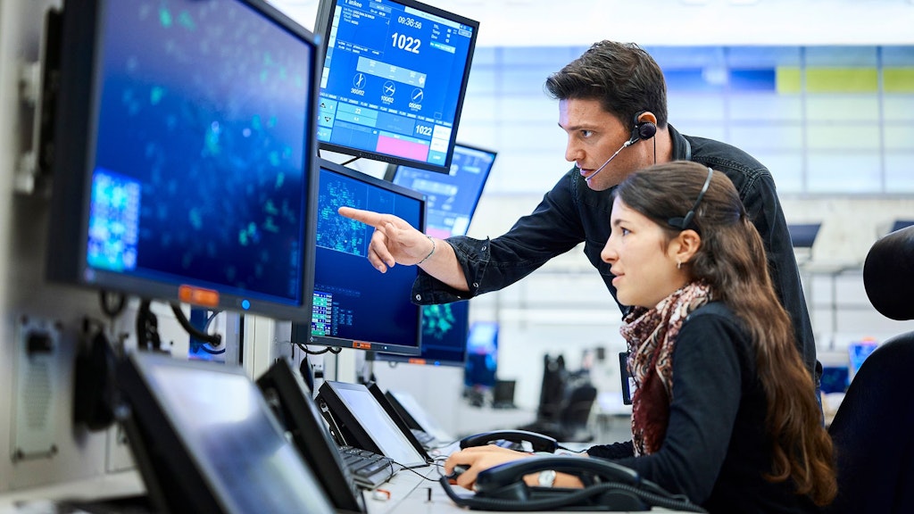 The picture shows a Skyguide air traffic control team at work.