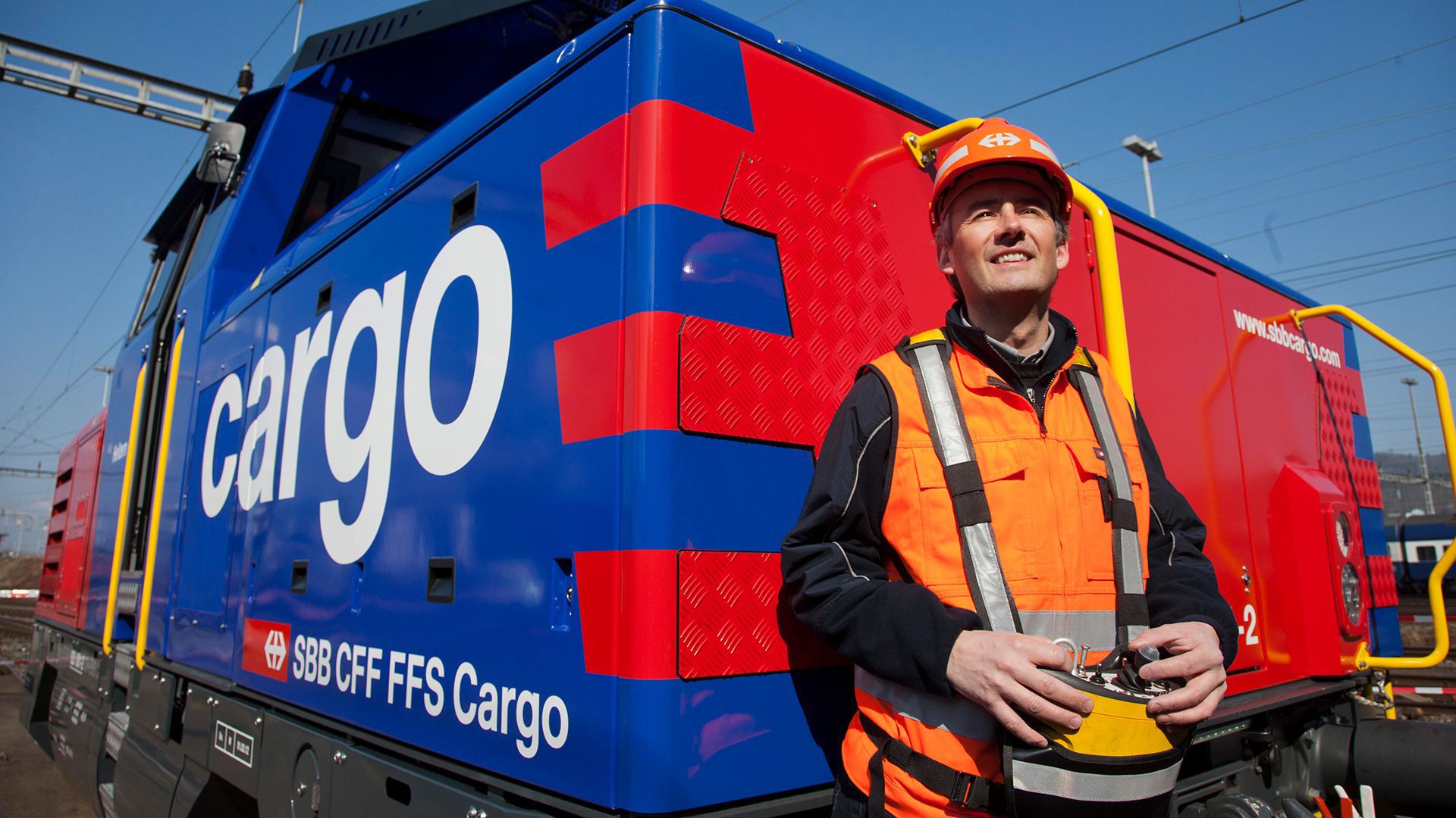 The picture shows an SBB Cargo shunting locomotive with an employee.