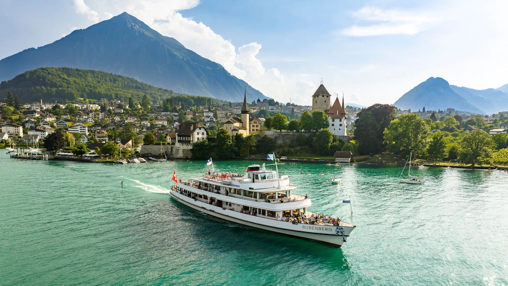 Das Schiff MS Bubenberg der BLS Schifffahrt fährt auf dem Thunersee, im Hintergrund das Schloss Spiez.