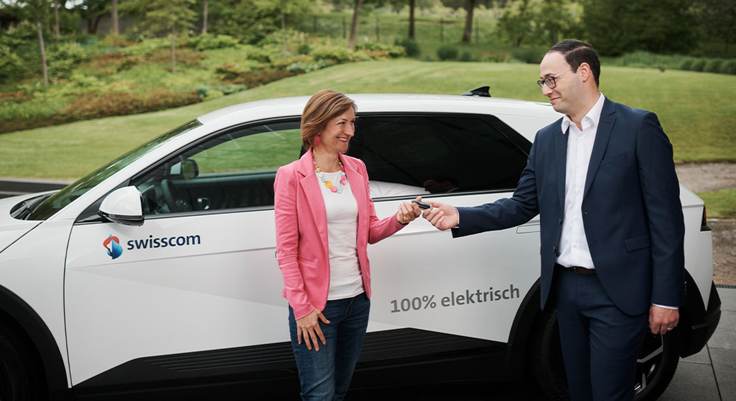 Das Bild zeigt die Schlüsselübergabe eines Elektroautos von Hyundai an Swisscom.